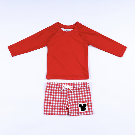 Boys red long sleeve rash guard and red gingham swim shorts featuring a hand smocked magical mouse patch.
