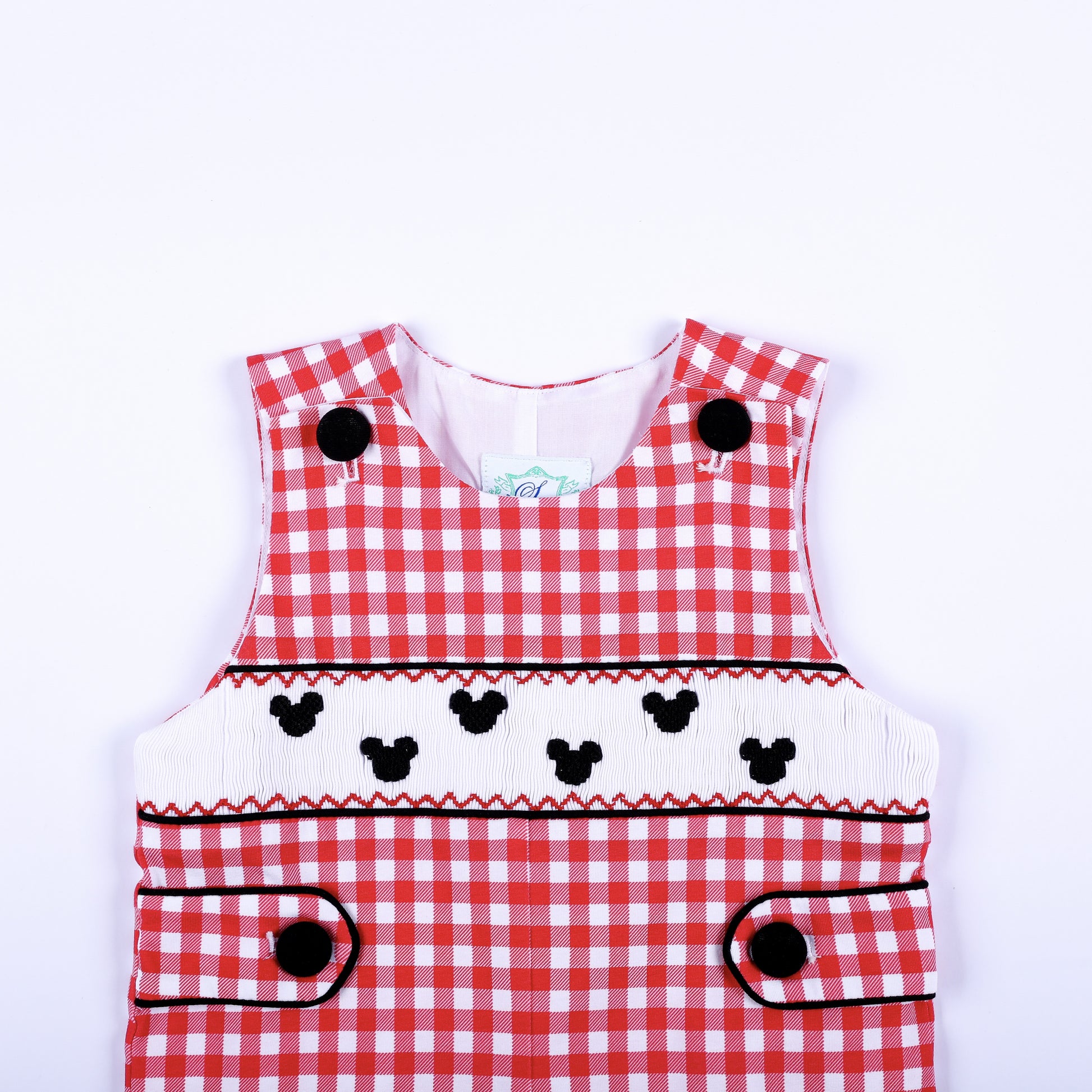 Close view of boys red gingham jon jon showing hand smocked chest panel with black embroidered mouse silhouettes.