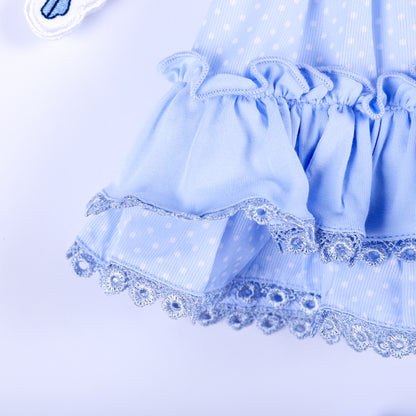 Close-up of tiered ruffle hem with blue lace edging on polka dot Cinderella smocked top for toddlers.