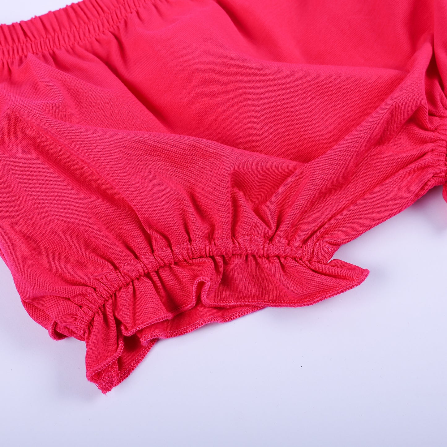 Detailed close up view of the dark pink ruffled bloomer fabric and elastic waistband from the Dolly & Me outfit.