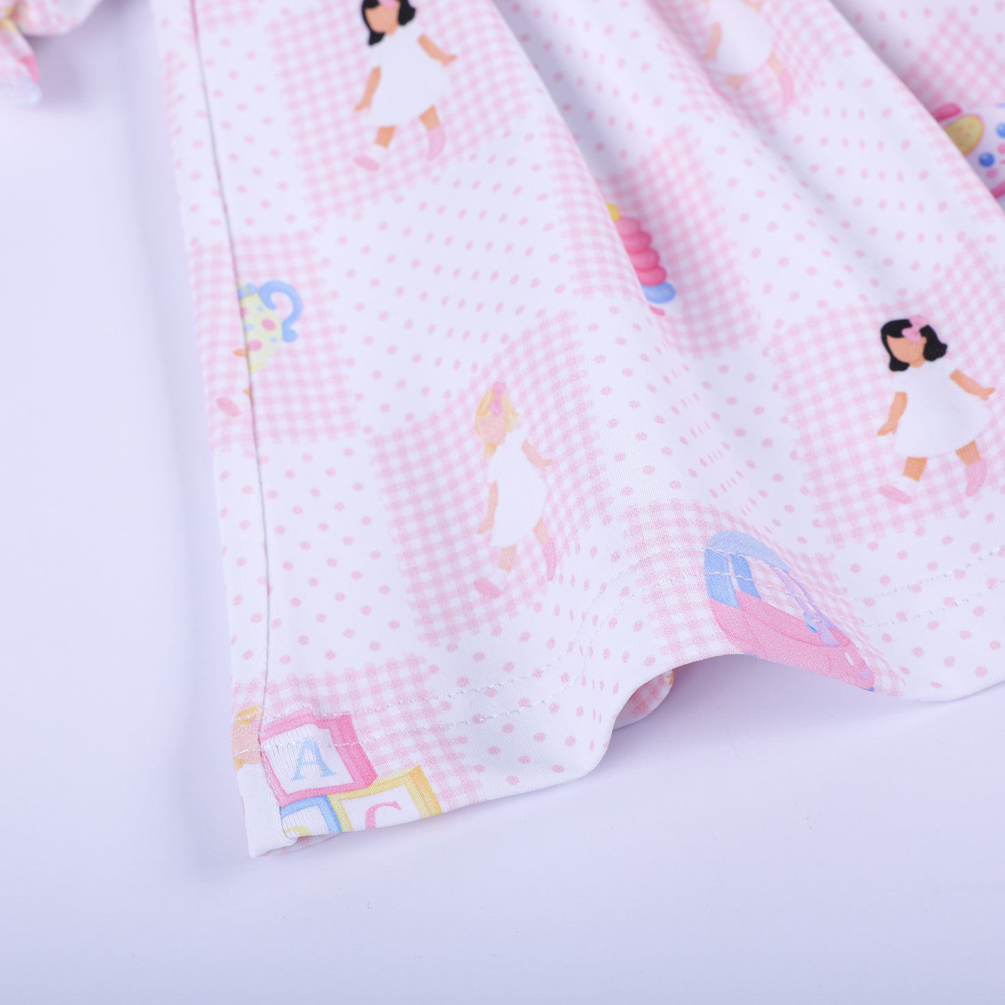 Close up of Dolly & Me custom knit pink checkerboard fabric pattern showing classic childhood vintage toy print.