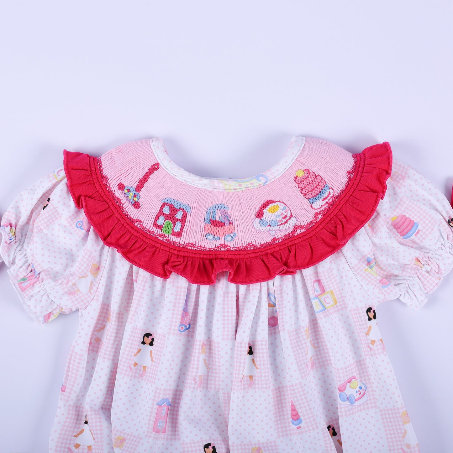 Close-up of the embroidered vintage toy collar on the Dolly & Me pink hand-smocked bubble romper for babies.