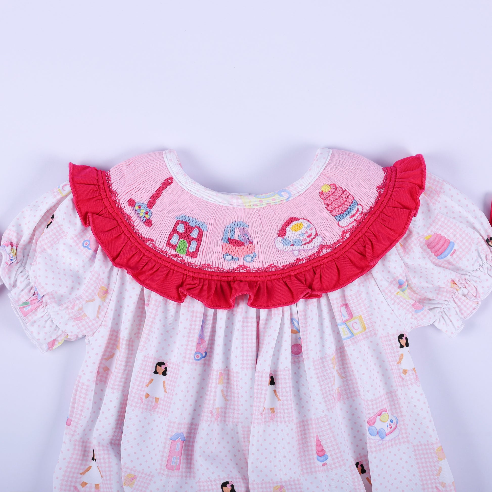 Close-up of the embroidered vintage toy collar on the Dolly & Me pink hand-smocked bubble romper for babies.