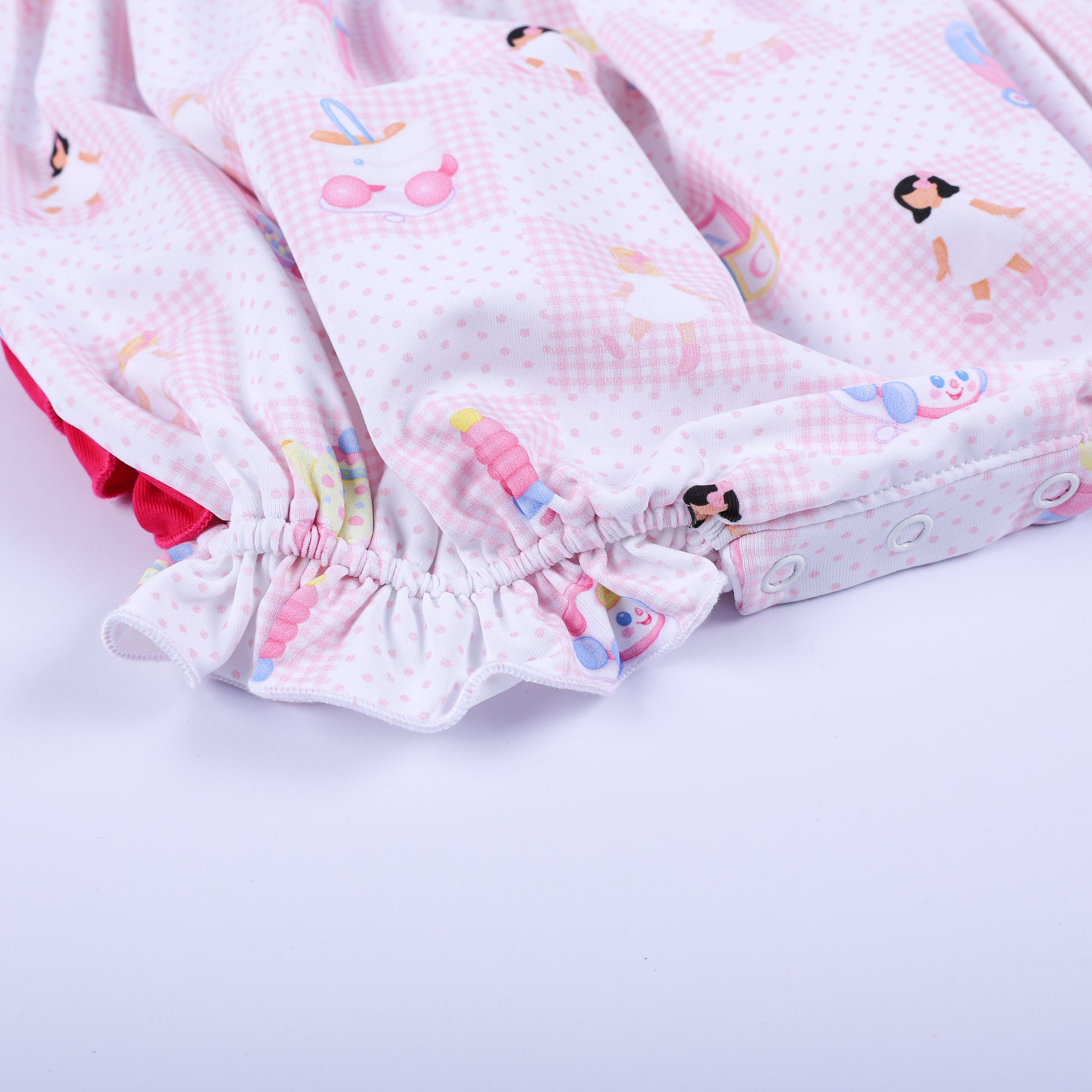 Close-up of the bottom diaper snaps and elastic ruffle leg opening on Dolly & Me pink checkered bubble romper.