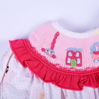 Macro shot of hand-embroidered nostalgic toy phone and pink dollhouse on Dolly & Me smocked clothing bubble.