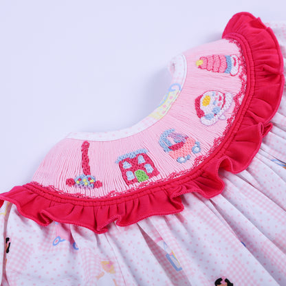 Detailed view of the hand-smocked pink collar with embroidered retro toy phones and houses on the baby romper garment.