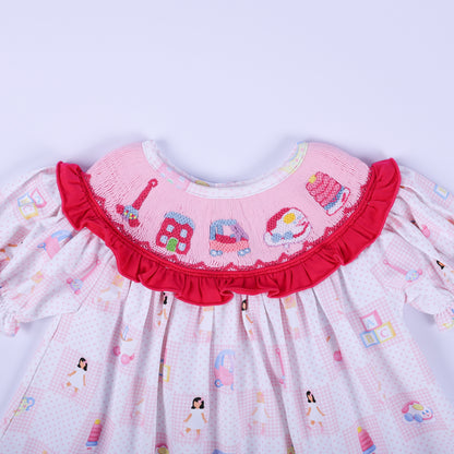 Detailed front view of Dolly & Me hand smocked ruffle collar with embroidered vintage childhood toys on tunic top.