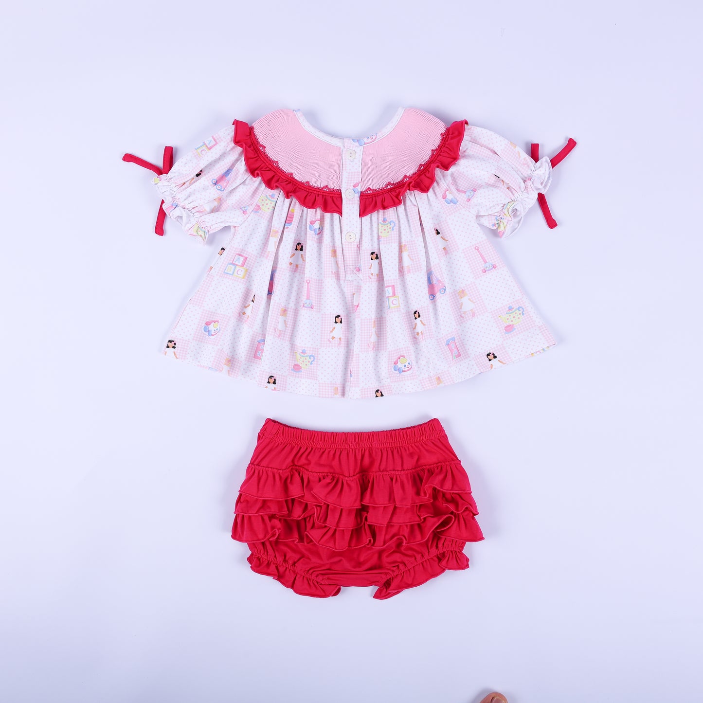 Back flat lay view of the Dolly & Me vintage toys tunic top with buttons and the dark pink tiered ruffled bloomers.