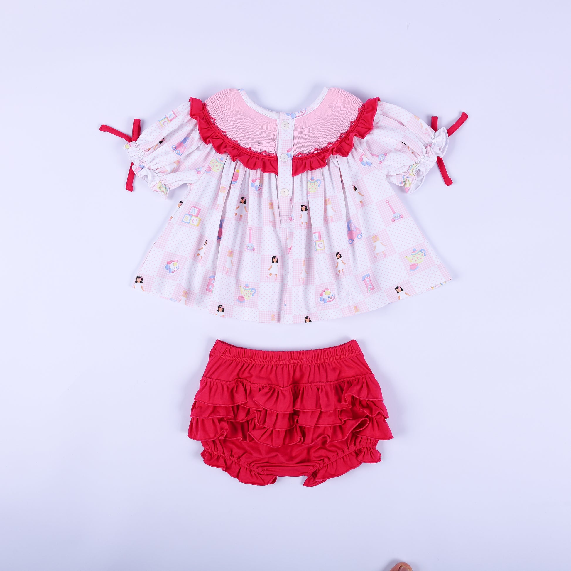 Back flat lay view of the Dolly & Me vintage toys tunic top with buttons and the dark pink tiered ruffled bloomers.