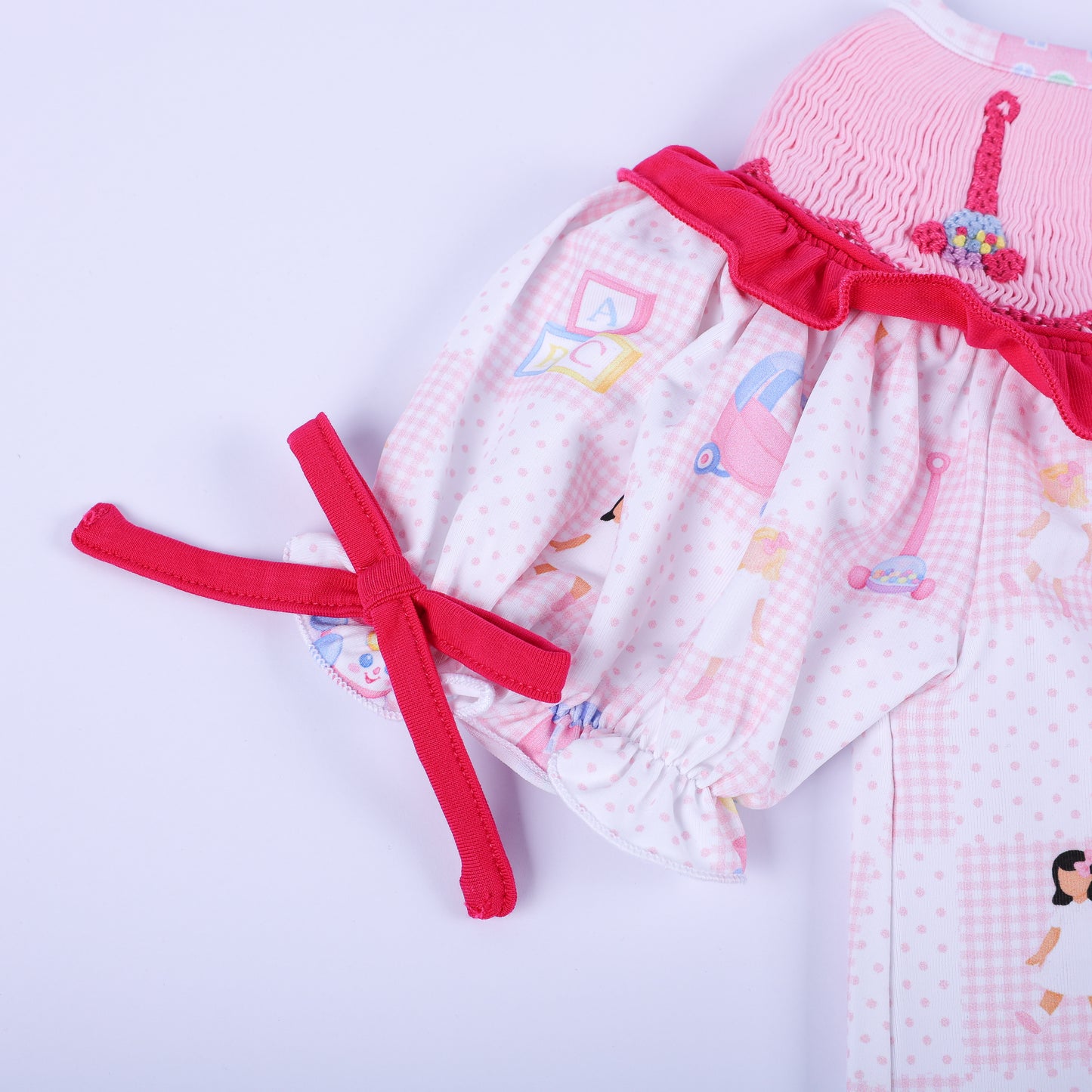Detailed close up of a puff sleeve with a dark pink bow tie on the Dolly & Me vintage toys checkerboard tunic top.