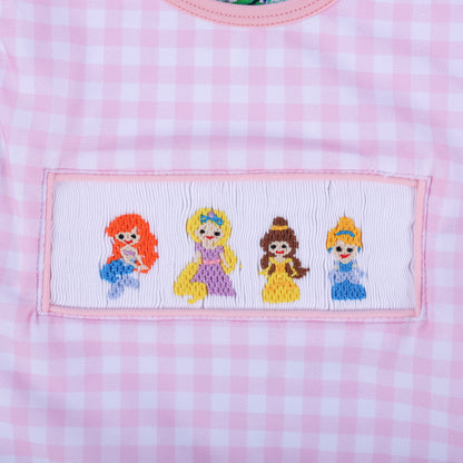 Detailed macro view of the four hand embroidered fairytale princesses on the smocked panel of the gingham swimwear.