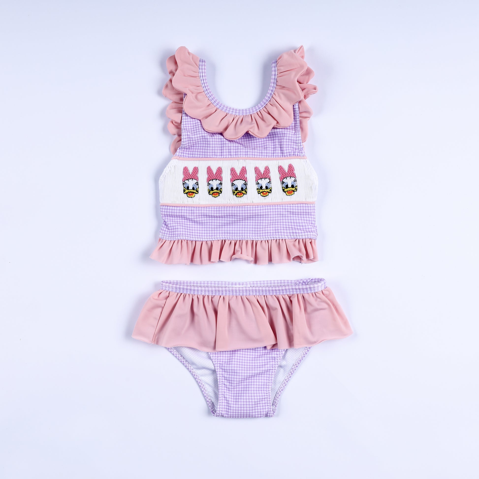 Girls purple gingham two-piece swimsuit featuring hand-smocked embroidered lady ducks and ruffle trim.