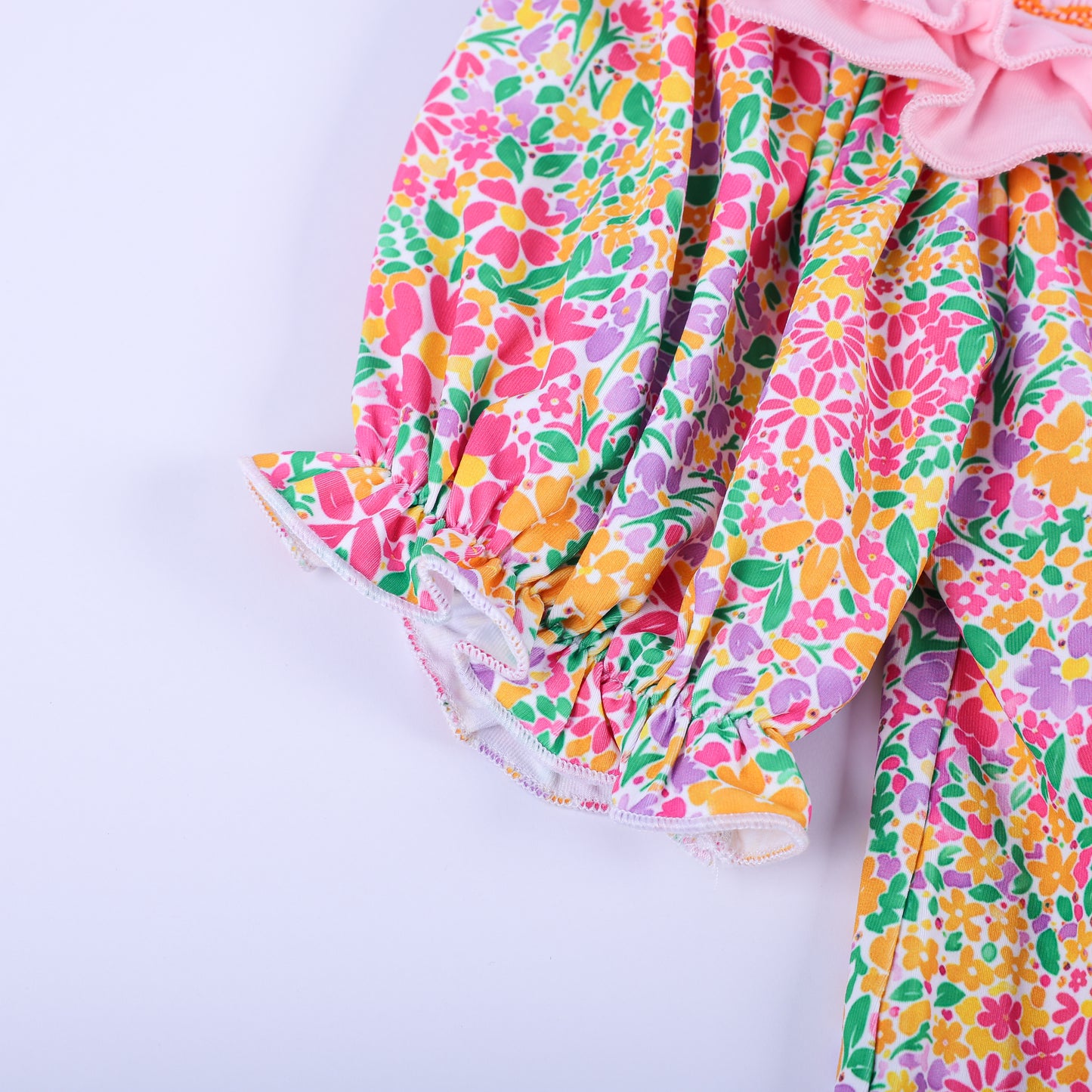 Close-up view of the vibrant pink, orange, and yellow floral ruffle puff sleeve on the boutique Thanksgiving tunic top.