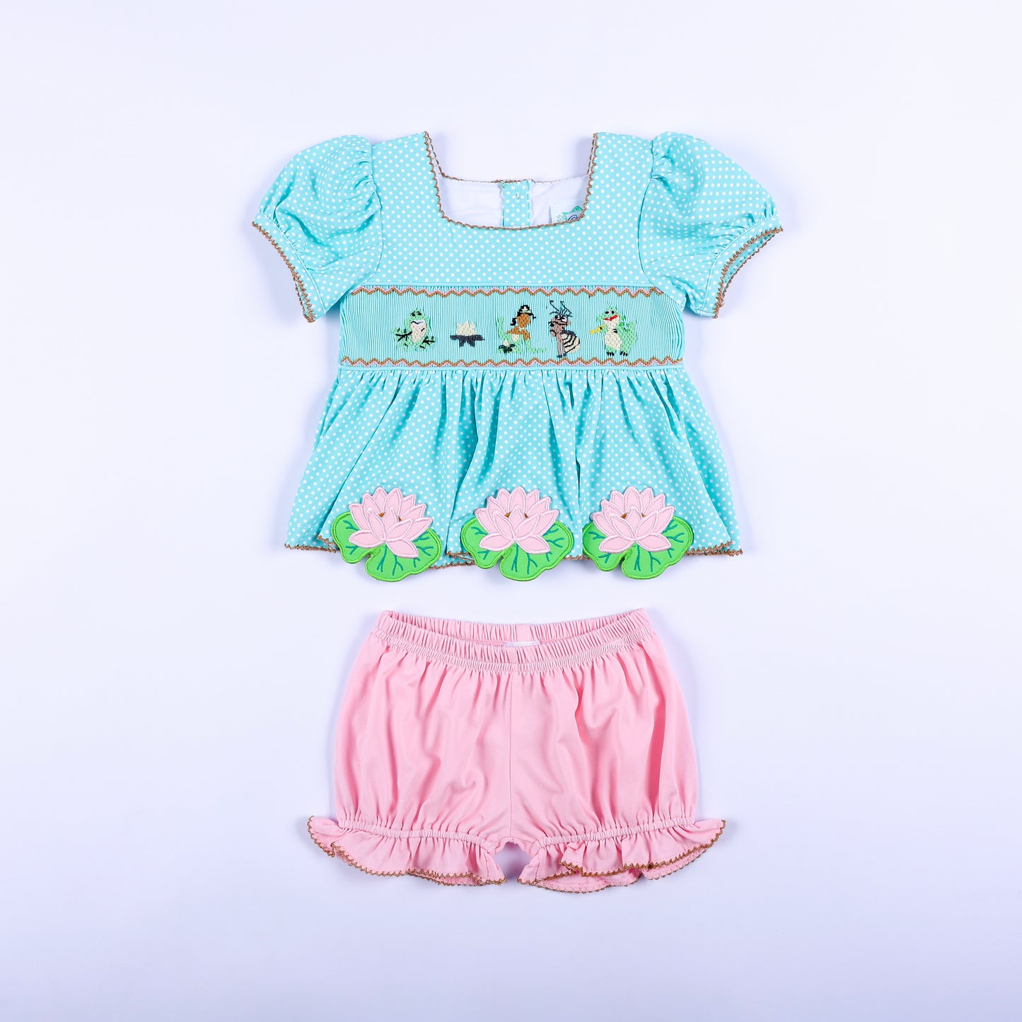 Full front view of frog princess hand smocked aqua polka dot top and pink bloomer set for toddler girls.
