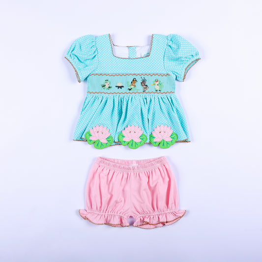 Full front view of frog princess hand smocked aqua polka dot top and pink bloomer set for toddler girls.