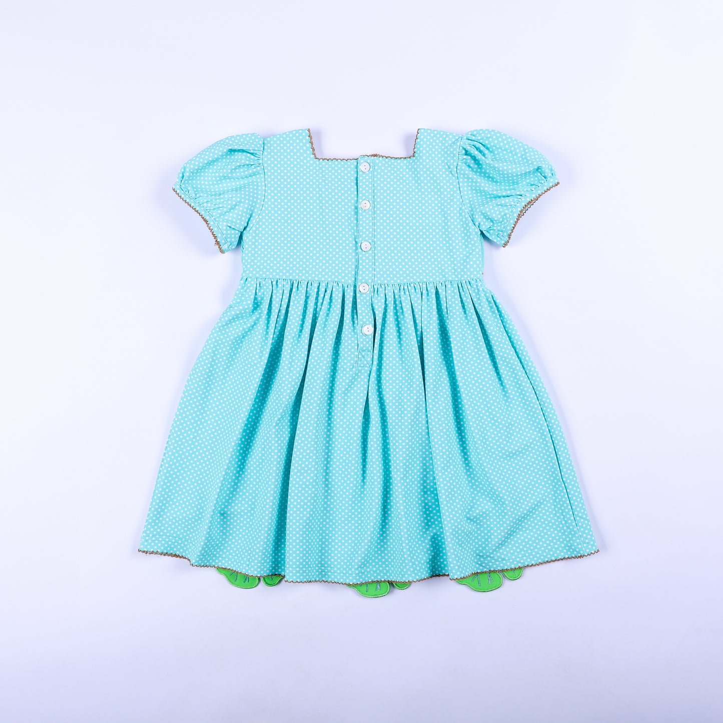 Full back view of girls aqua polka dot frog princess hand smocked dress featuring classic button back closure.