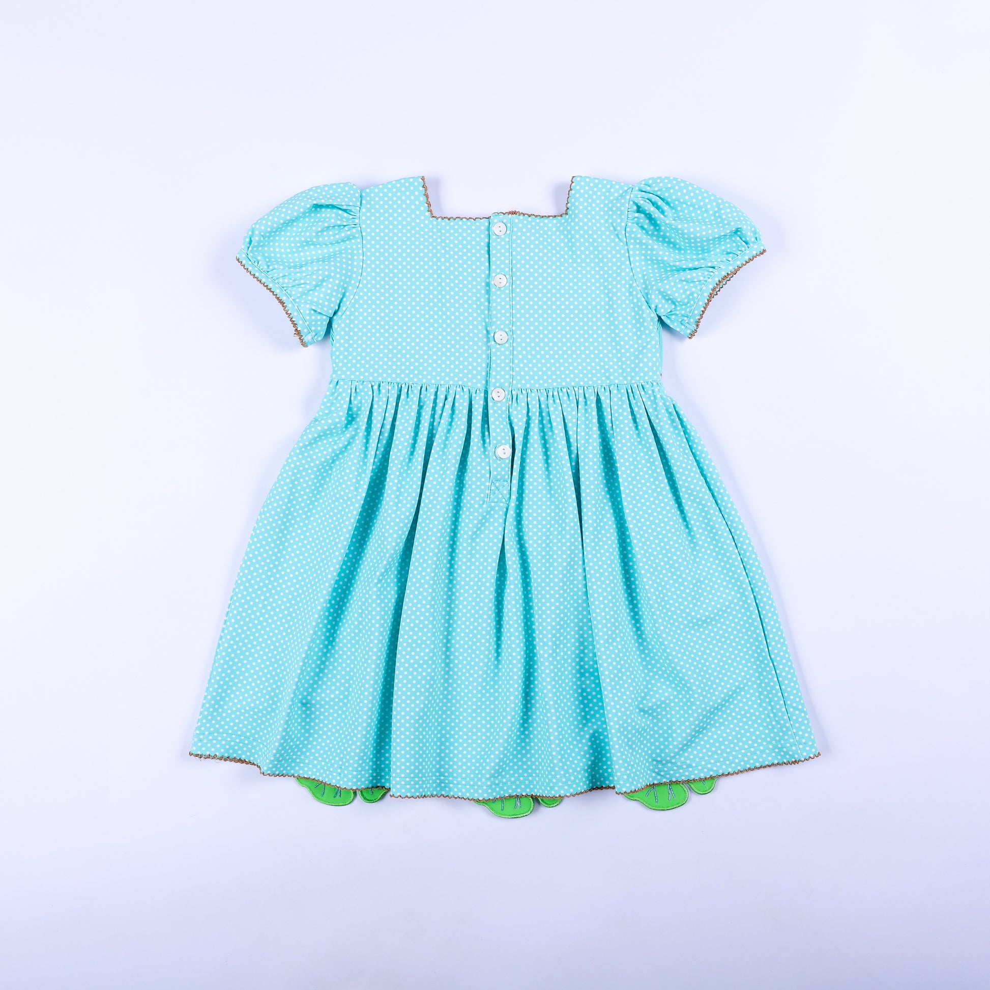 Full back view of girls aqua polka dot frog princess hand smocked dress featuring classic button back closure.