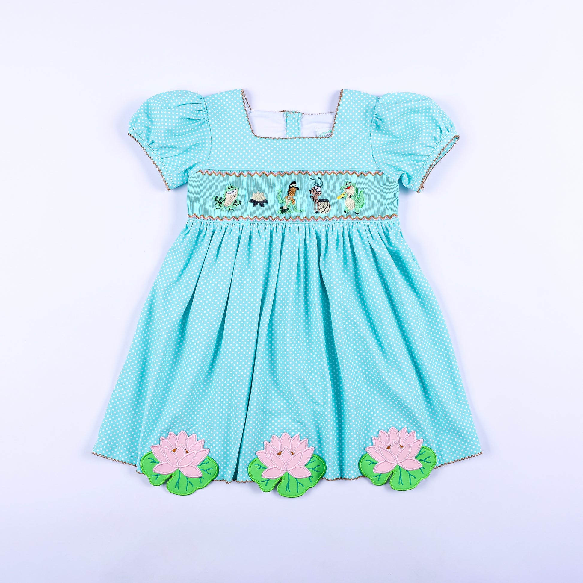 Girls aqua polka dot frog princess hand smocked dress featuring hand embroidered bodice and lotus flower hem.