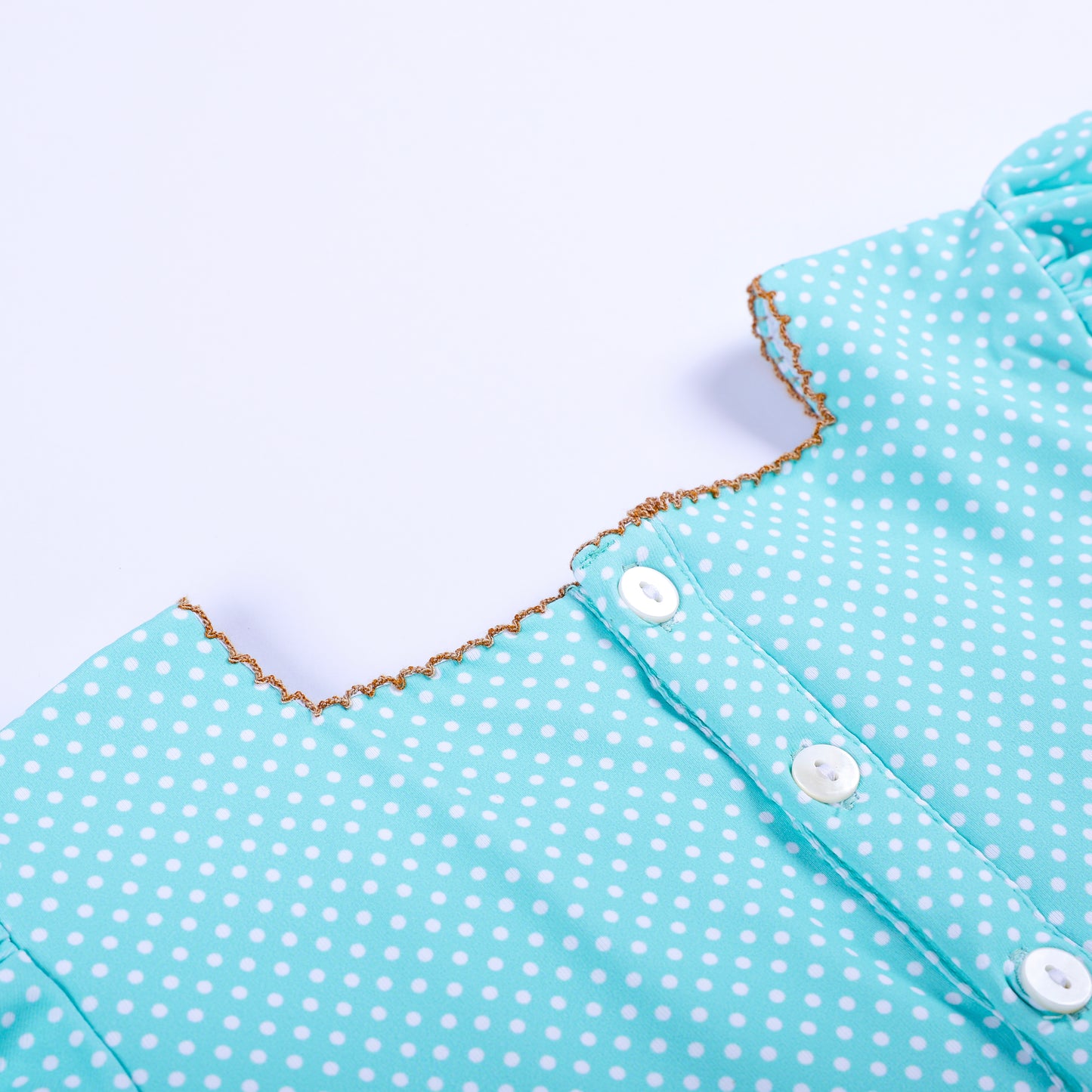 Detailed close-up view of back button placket and picot trimmed collar on girls frog princess smocked dress.