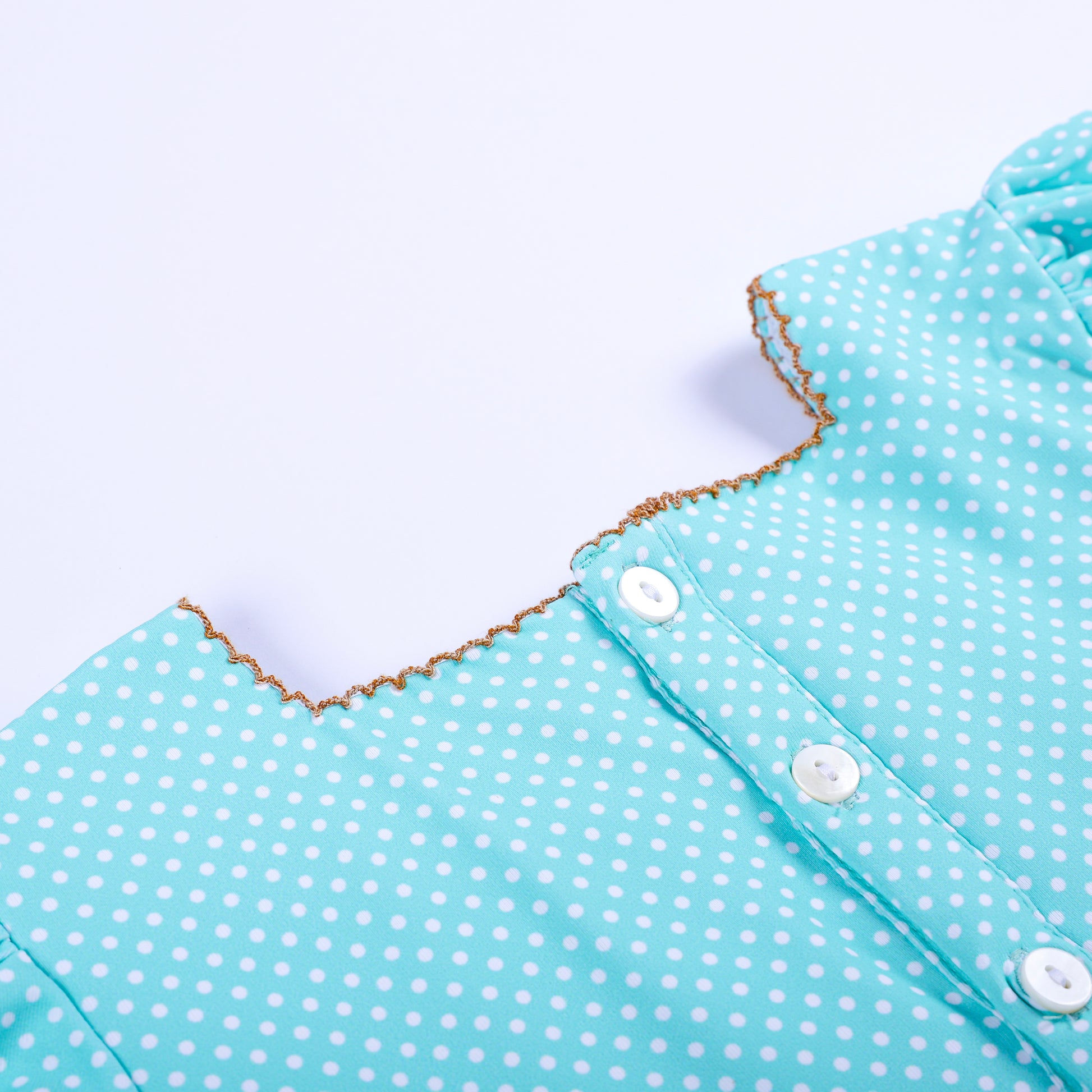 Detailed close-up view of back button placket and picot trimmed collar on girls frog princess smocked dress.