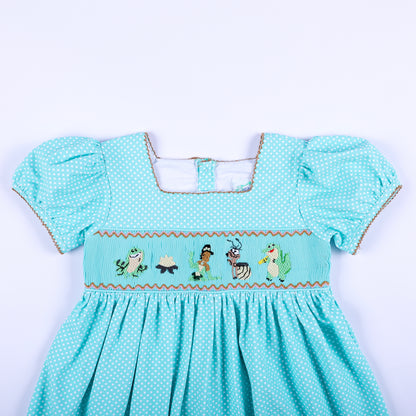 Front bodice view of girls frog princess hand smocked dress with embroidered characters and puff sleeves.