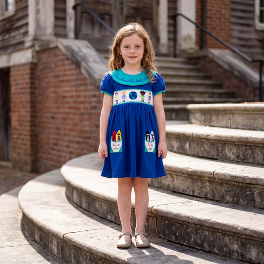 Young girl wearing a blue smocked dress with an embroidered teal collar and crayon-shaped pockets