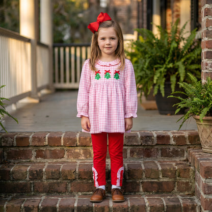 Girl in pink gingham smocked top with three Christmas trees and red ruffled pants from the Embroidered Christmas Tree Trio set.