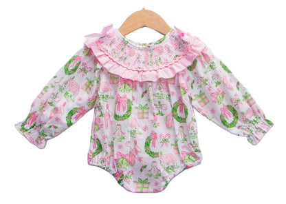 Baby girls Christmas watercolor smocked bubble romper with pink ruffled collar hanging on wooden hanger.