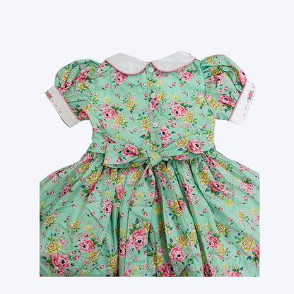 Back of girls mint floral smocked dress featuring button placket and tied sash bow