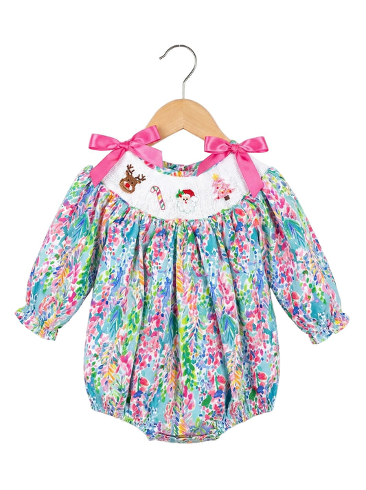Colorful baby romper with floral pattern and pink bows on a white background