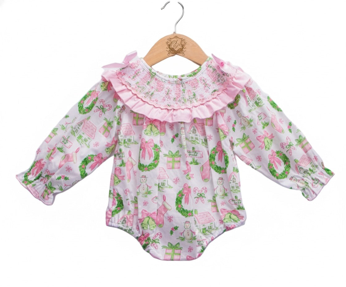 Front view of baby girls Christmas watercolor smocked bubble romper with pink bow collar and garland print.