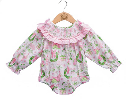 Front view of baby girls Christmas watercolor smocked bubble romper with pink bow collar and garland print.