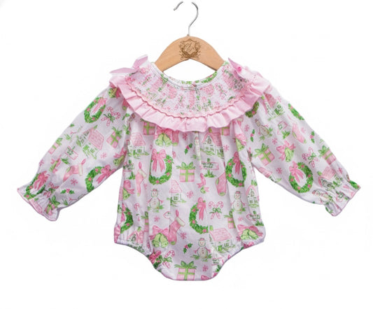 Front view of baby girls Christmas watercolor smocked bubble romper with pink bow collar and garland print.