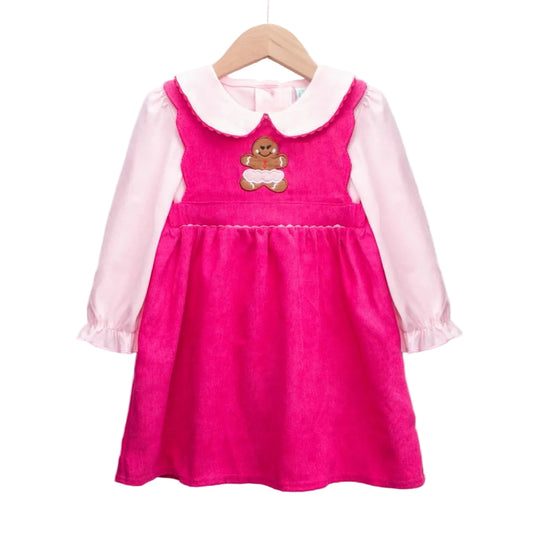Girls pink corduroy dress with cute gingerbread applique and long sleeve Peter Pan collar shirt on white background.