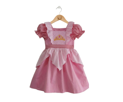 Pink kids princess dress featuring puff sleeves, a scalloped overlay, and an embroidered gold crown.