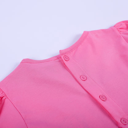 Close-up view of pink button closures on the back bodice of girls fancy hand smocked polka dot dress.