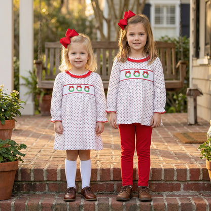 Siblings in matching white smocked Christmas wreath trio dress and tunic set. Perfect holiday outfits.