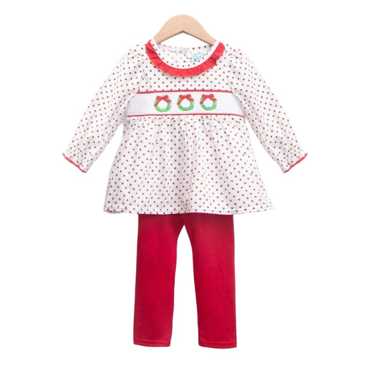 Girls white smocked Christmas wreath top with red polka dots and ruffled collar, and matching red pants on a hanger.