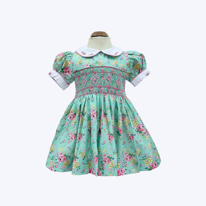 Mannequin front view of girls hand-smocked vintage floral dress in mint green