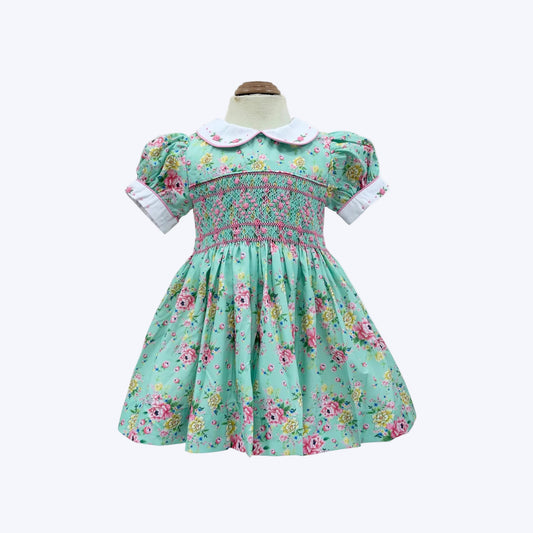 Mannequin front view of girls hand-smocked vintage floral dress in mint green