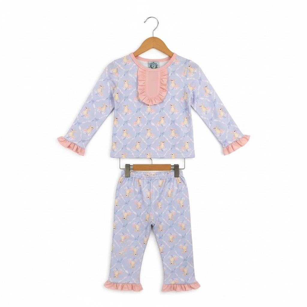 Grandmillennial Easter bunny girl pajama set with pink ruffle collar and sleeve details hanging on wooden hangers.