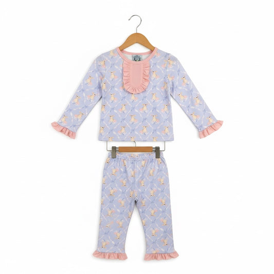 Grandmillennial Easter bunny girl pajama set with pink ruffle collar and sleeve details hanging on wooden hangers.