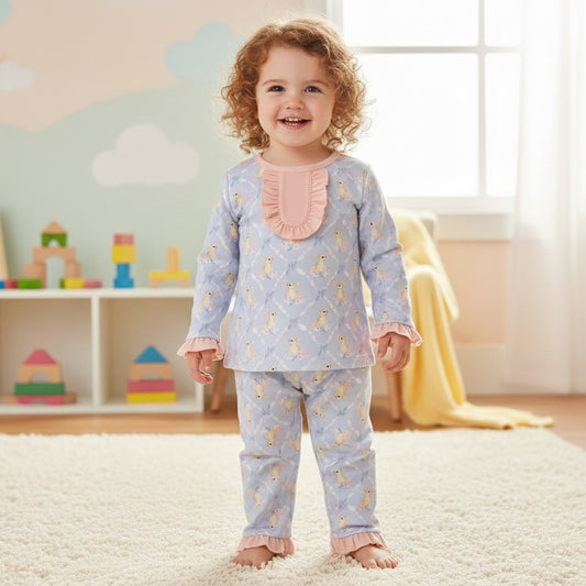 Toddler wearing the blue Grandmillennial Easter Bunny girl pajama set with pink ruffle collar in a playroom.