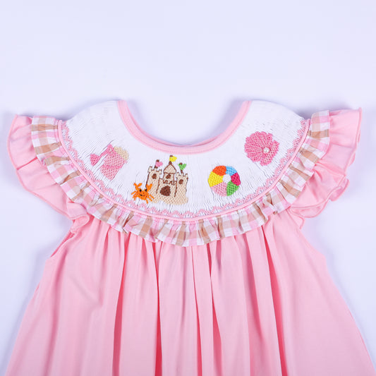 Close-up of hand embroidered beach collar with sandcastle, crab, beach ball, and pink shell on smocked dress.