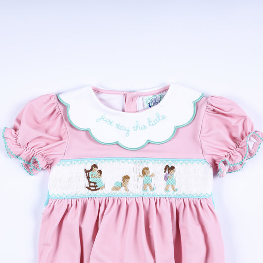 Upper front detail of hand smocked pink bubble showing embroidered collar quote and baby milestone smocking design.