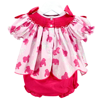 view of hand smocked frosted sprinkle animal cookies set top with button closure detail and pink ruffle bloomers.