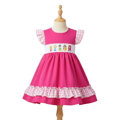 Hand smocked pink dress with embroidered princesses on the bodice and pink gingham ruffle trim and sleeves.