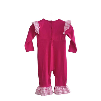Back view of hand smocked pink princess girl romper featuring button closures and gingham ruffle trim.