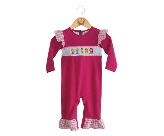 Front view of hand smocked pink princess girl romper with embroidered princess detail and gingham ruffles.