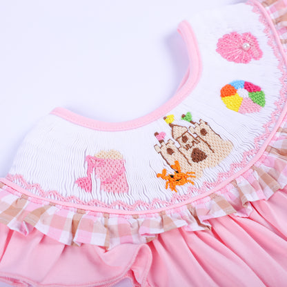 Intricate hand smocked collar featuring hand embroidered sandcastle, orange crab, and bucket motifs for girls.